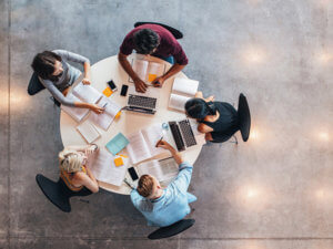 aerial photo of five college students studying together at a round table