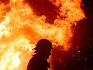 silhouette of a firefighter against a raging fire