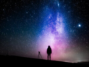 silhouette of a person standing against the night sky with stars